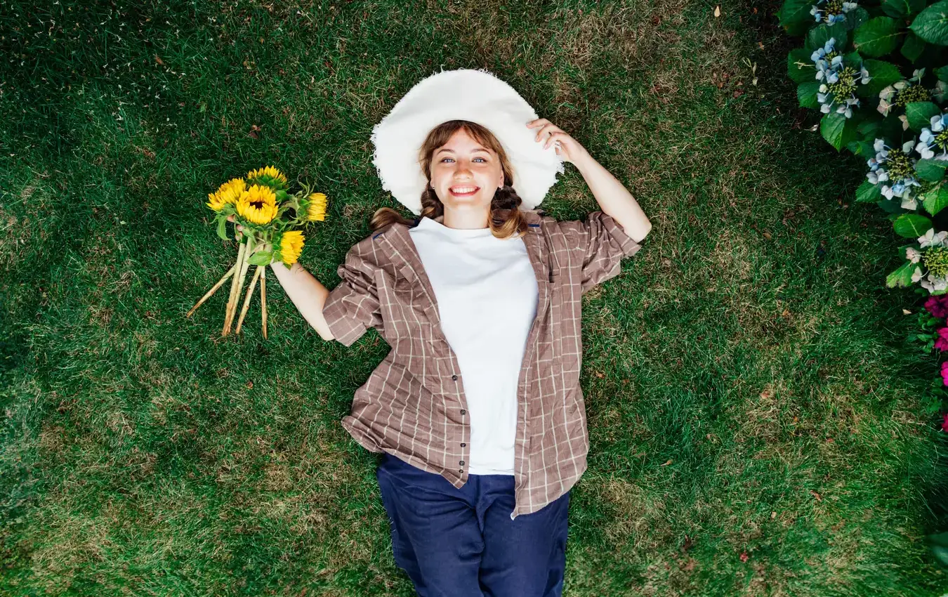 Donna felice in un giardino fiorito con girasoli